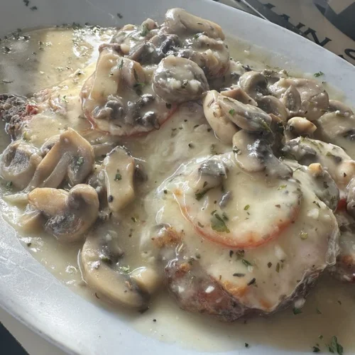 Chicken Sinatra - Lightly breaded chicken breast topped with proscuttini, sliced tomato, and mozzarella cheese covered with a delicious mushroom and white wine sauce.